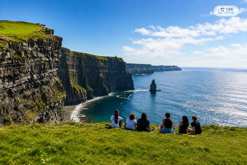 Visitors enjoying panoramic views from the Cliffs of Moher overlooking Ireland’s dramatic Atlantic coastline