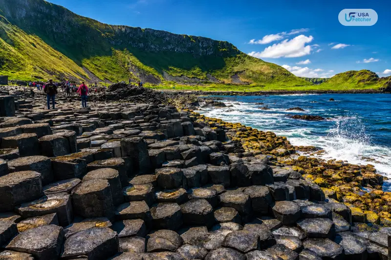 Visitors exploring the hexagonal basalt columns of Giant’s Causeway along Northern Ireland’s rugged coastline